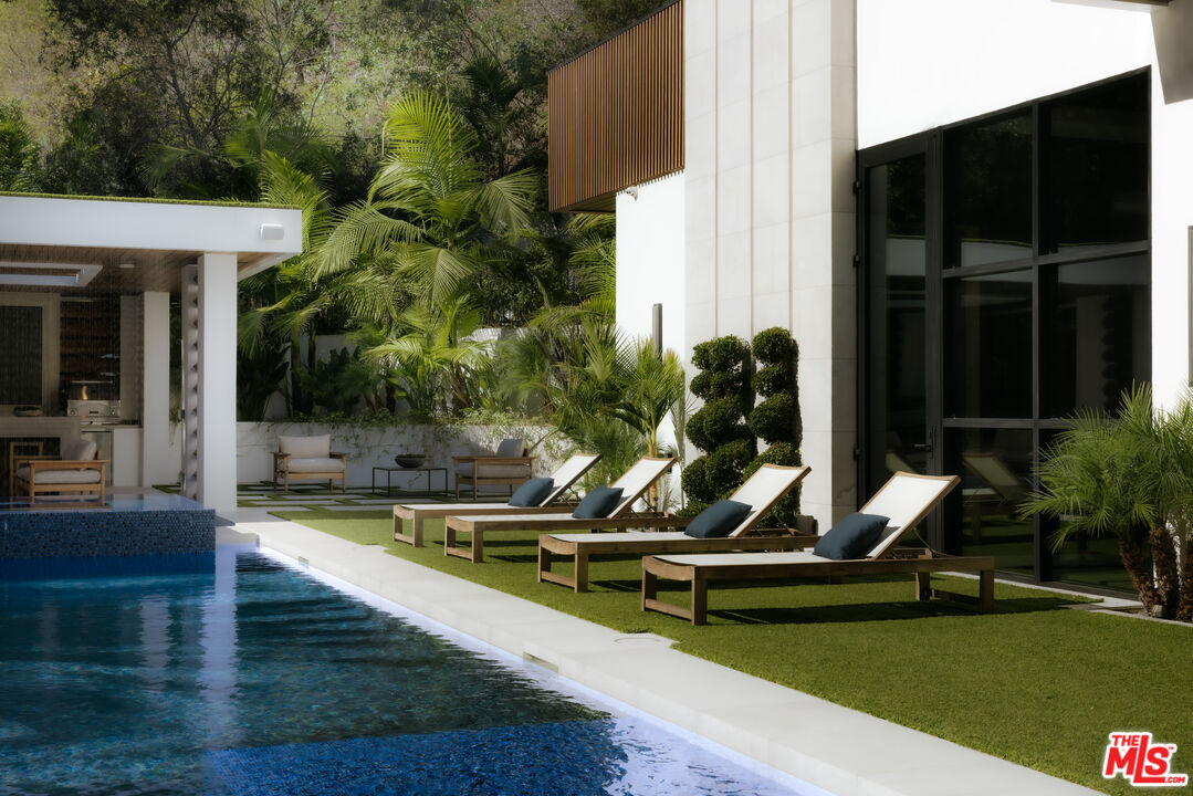 13187 Chalon Road Los Angeles, CA 90049 - Photo 31 of 39 a view of a swimming pool with sitting area and garden