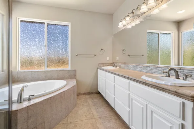 a kitchen with granite countertop a sink stainless steel appliances white cabinets and wooden floor