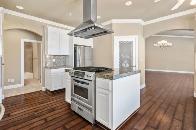 a kitchen with granite countertop white cabinets and window