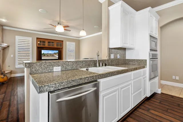 a kitchen with granite countertop a sink and cabinets