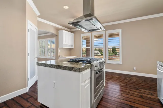 a kitchen with granite countertop a stove and a refrigerator
