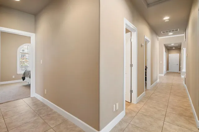 a spacious bedroom with a bed and a chandelier