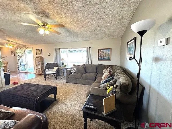 a kitchen with stainless steel appliances granite countertop a stove top oven a refrigerator a dining table and chairs with wooden floor