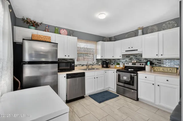 a kitchen with granite countertop a refrigerator stove top oven and sink