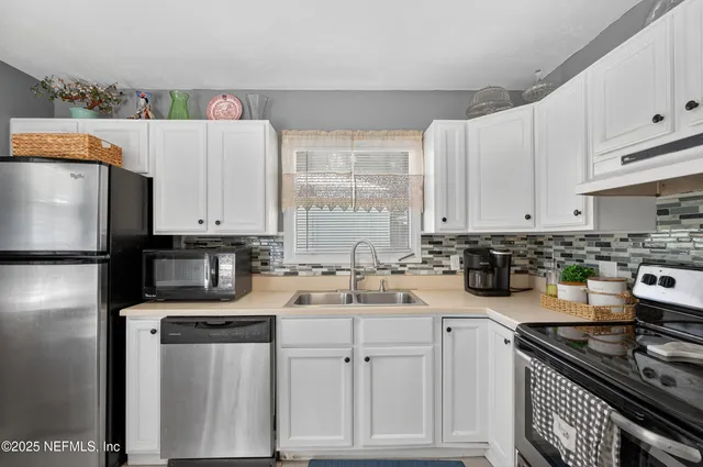 a kitchen with a sink a stove and cabinets