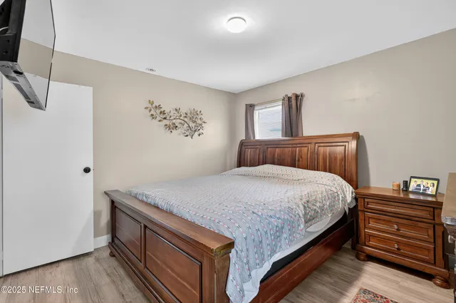 a bedroom with a bed and wooden floor
