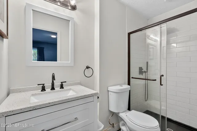 a bathroom with a sink a toilet and shower