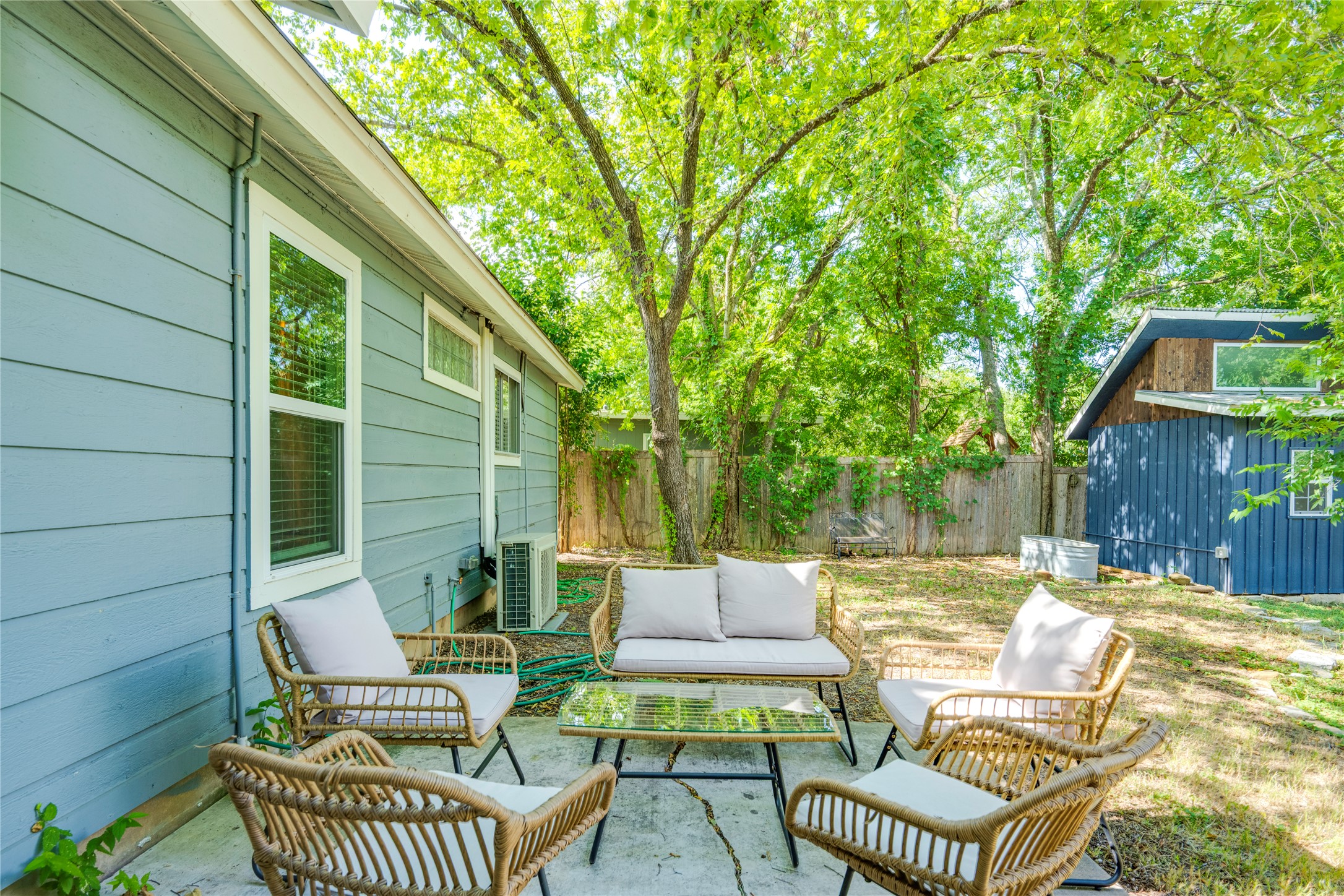 5300 Halmark Drive Austin, TX 78723 - Photo 36 of 40 An inviting concrete patio provides a comfortable outdoor gathering space, shaded by abundant mature trees.