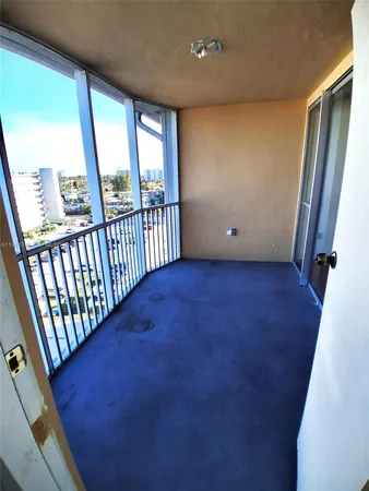 a view of a balcony with wooden floor and iron fence