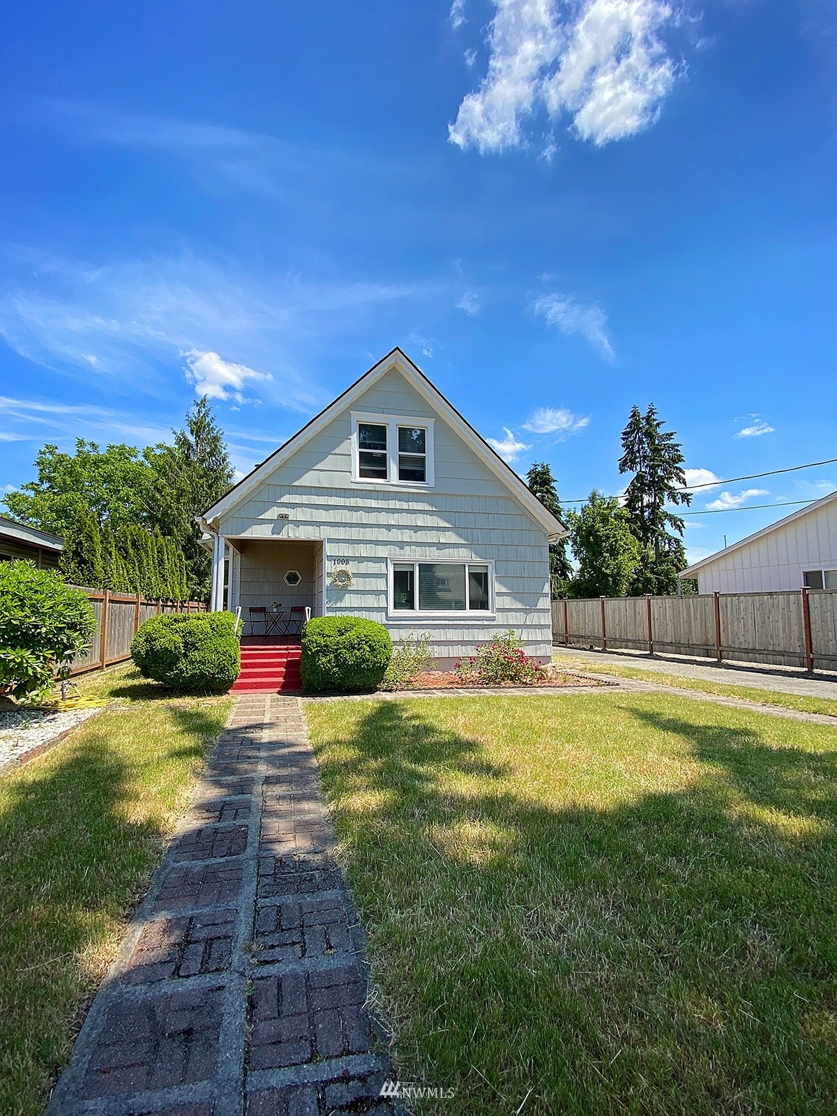 a front view of house with yard and trees in the background
