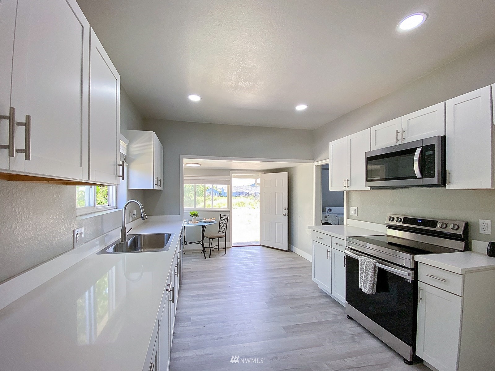 1005 9th Street Southwest Puyallup, WA 98371 - Photo 12 of 40 a kitchen with stainless steel appliances a stove a sink a microwave a refrigerator and cabinets