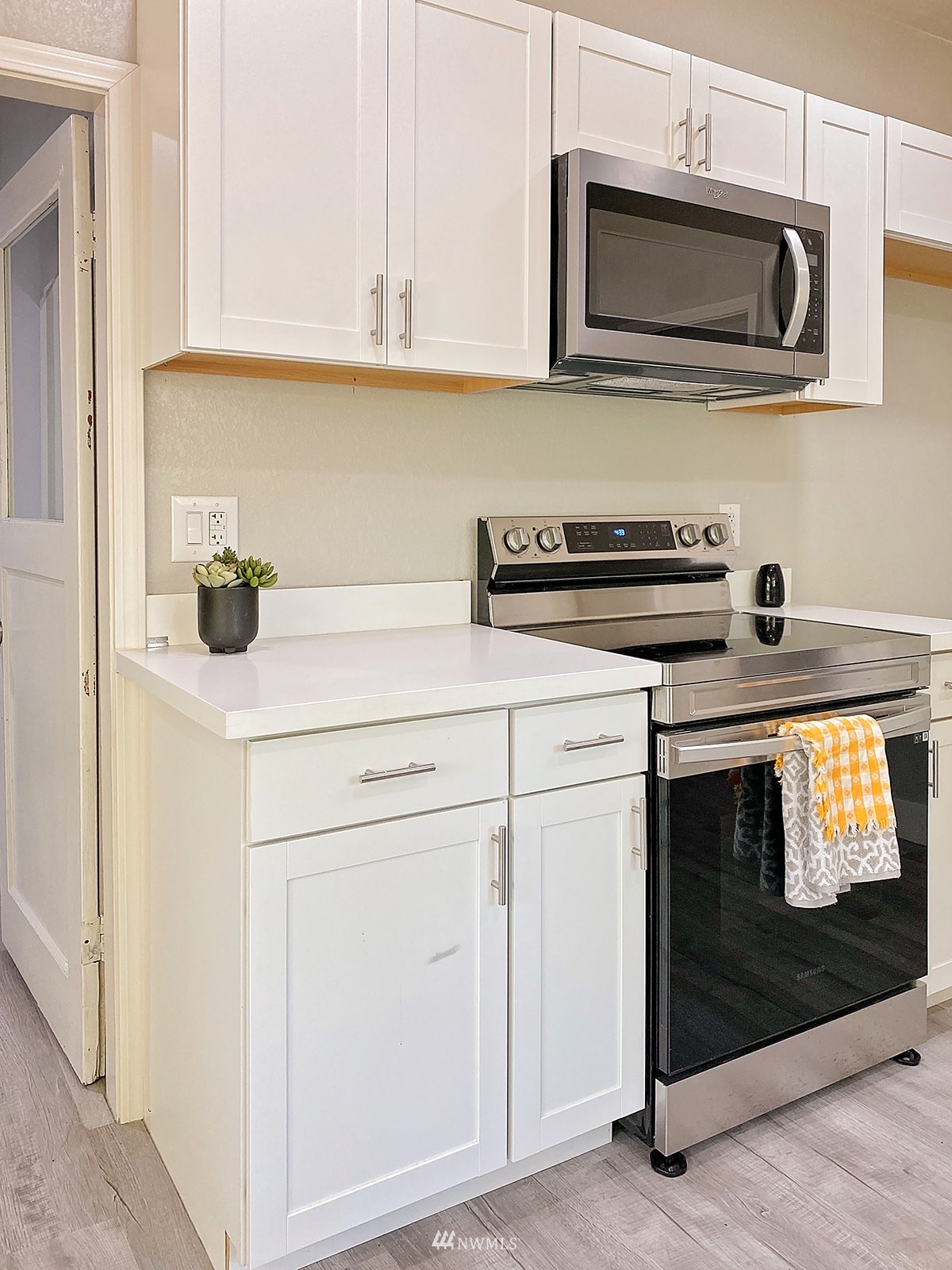 1005 9th Street Southwest Puyallup, WA 98371 - Photo 15 of 40 a kitchen with white cabinets and stainless steel appliances