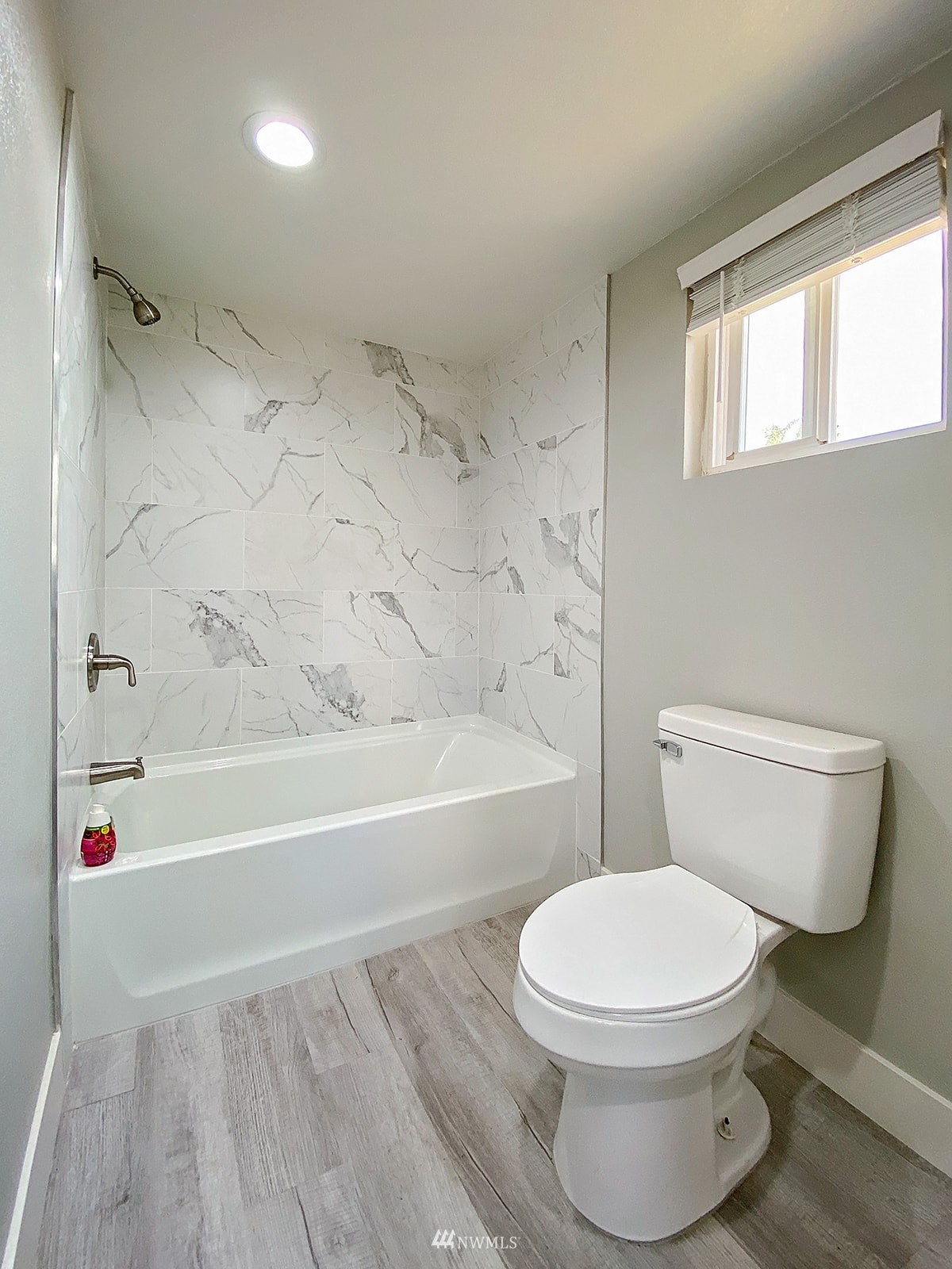 1005 9th Street Southwest Puyallup, WA 98371 - Photo 31 of 40 a white toilet and tub sitting next to a bathroom sink