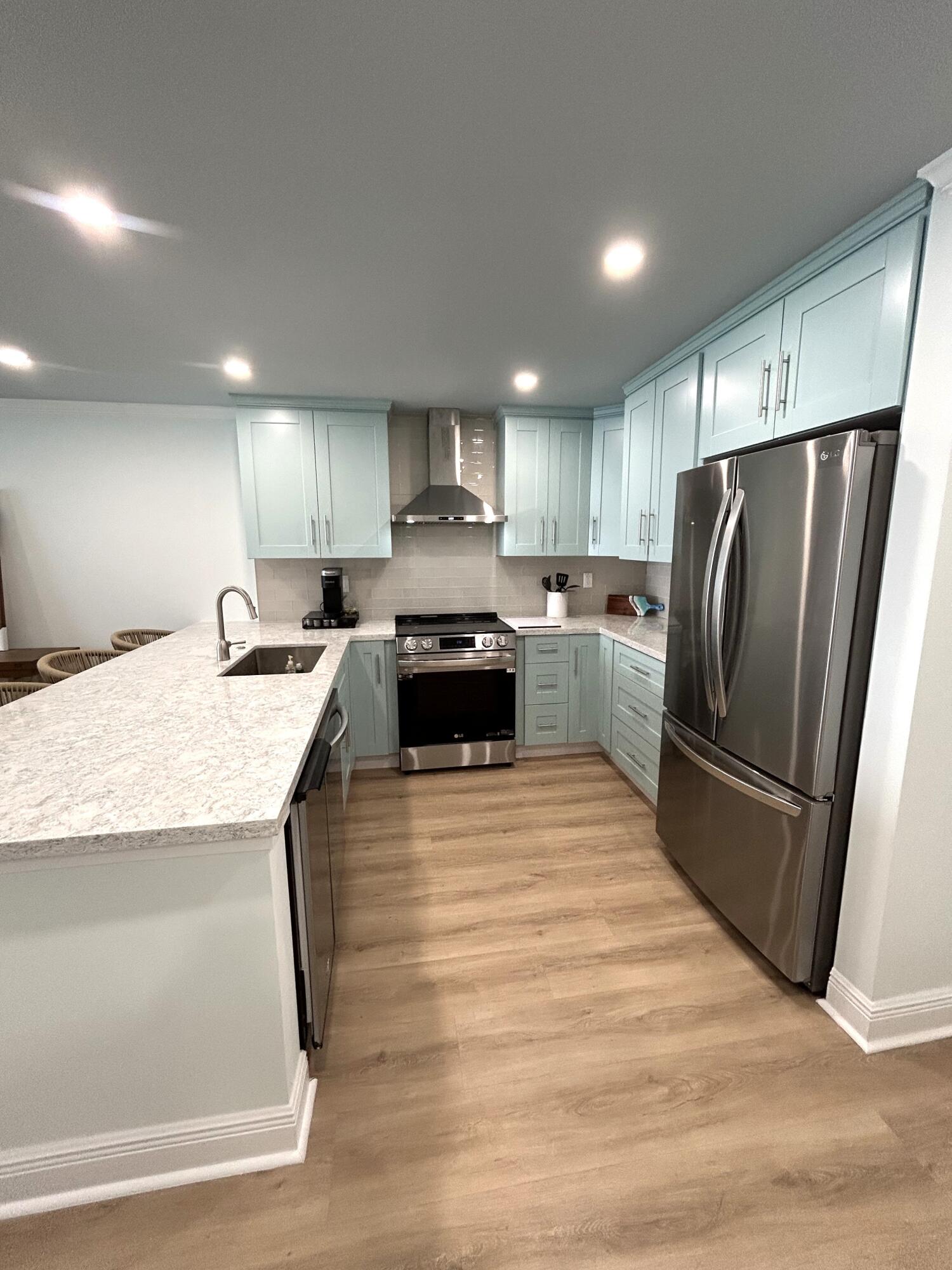 400 North Surf Road, Unit 1105 Hollywood, FL 33019 - Photo 4 of 15 a kitchen with granite countertop a refrigerator a sink a stove a microwave and island