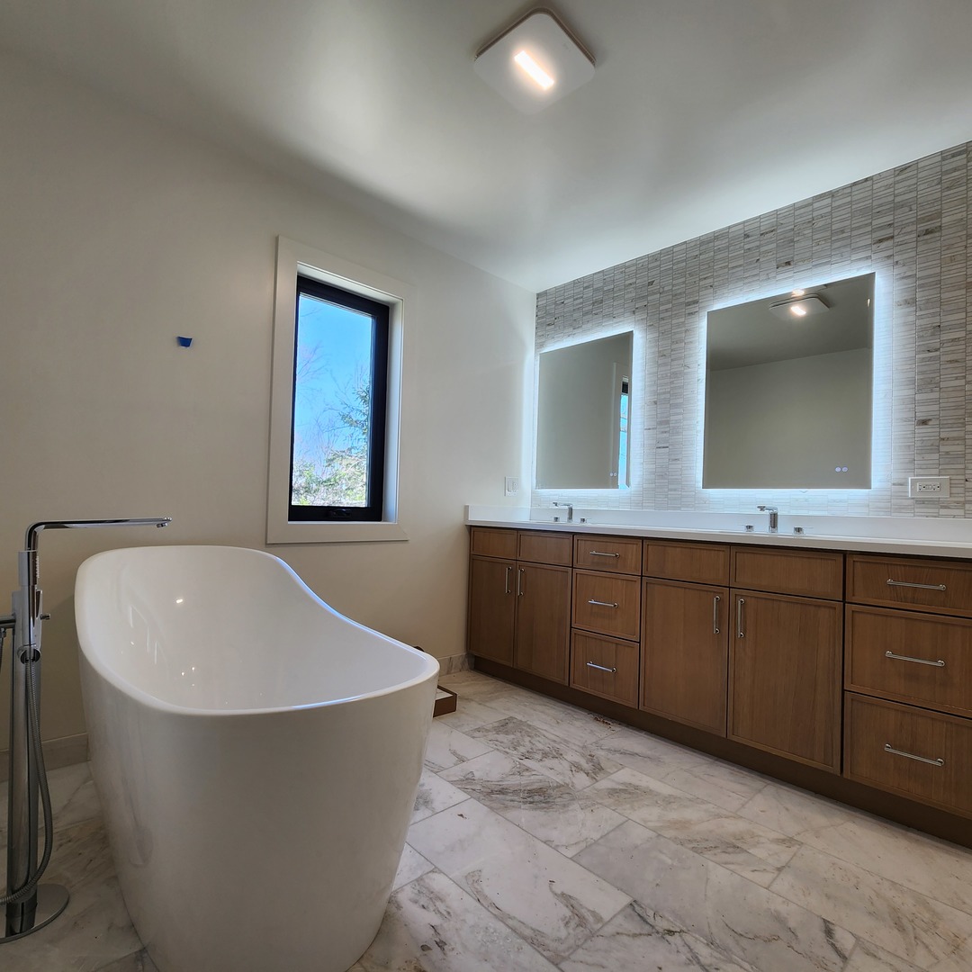 1975 Sunset Ridge Road Northfield, IL 60093 - Photo 16 of 21 a spacious bathroom with a bathtub sink and mirror