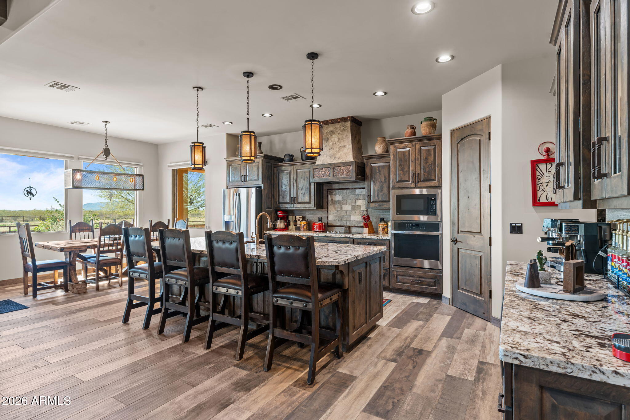 46629 West Luray Road Wickenburg, AZ 85390 - Photo 23 of 64 a kitchen with stainless steel appliances granite countertop a refrigerator oven a sink dishwasher and a dining table with wooden floor