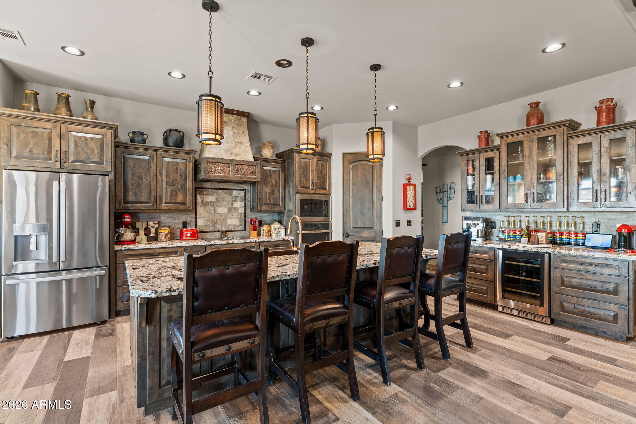 46629 West Luray Road Wickenburg, AZ 85390 - Photo 24 of 64 a kitchen with stainless steel appliances granite countertop a dining table chairs refrigerator and cabinets