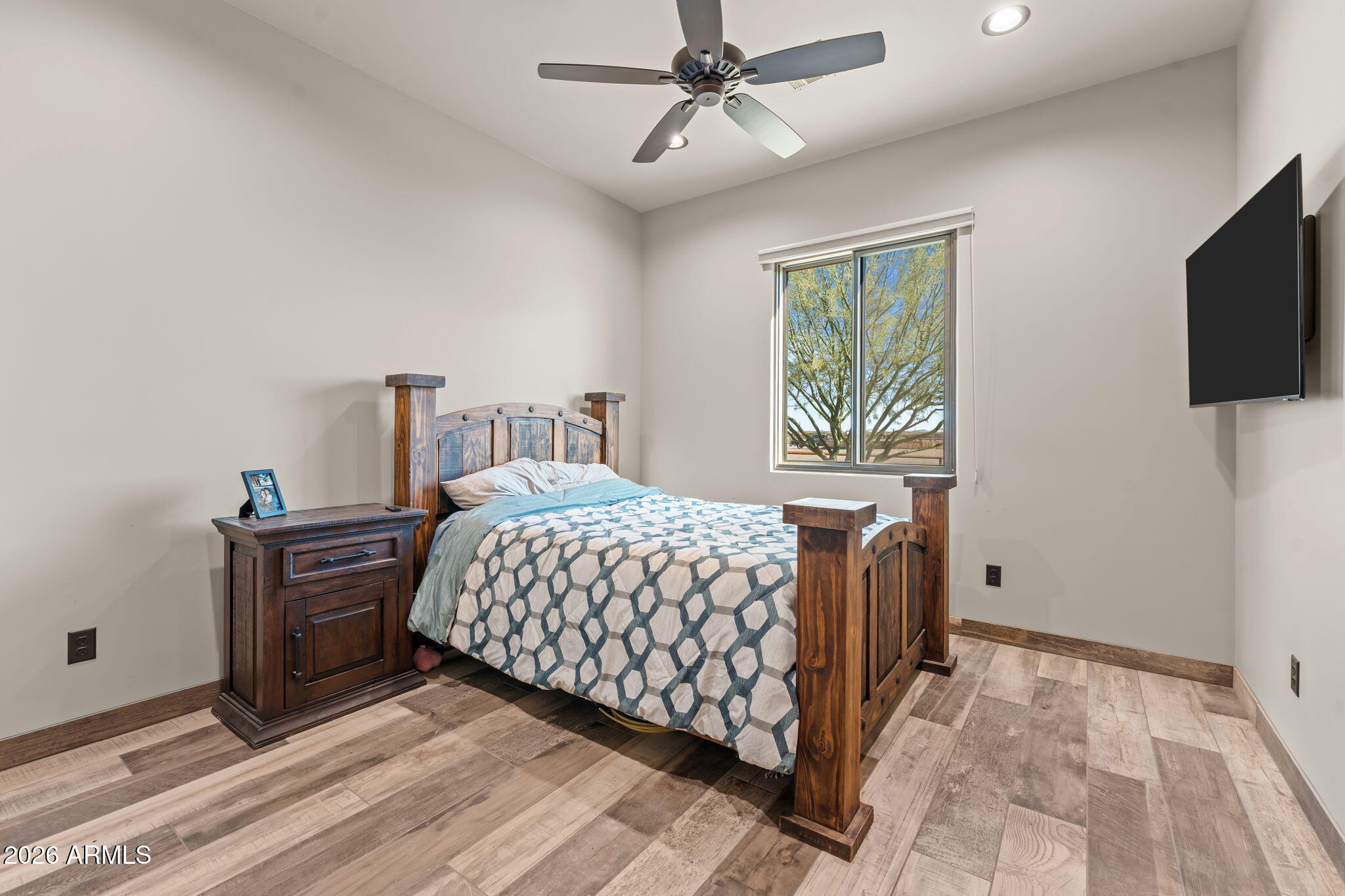 46629 West Luray Road Wickenburg, AZ 85390 - Photo 33 of 64 a bedroom with a bed and a flat tv screen on the dresser