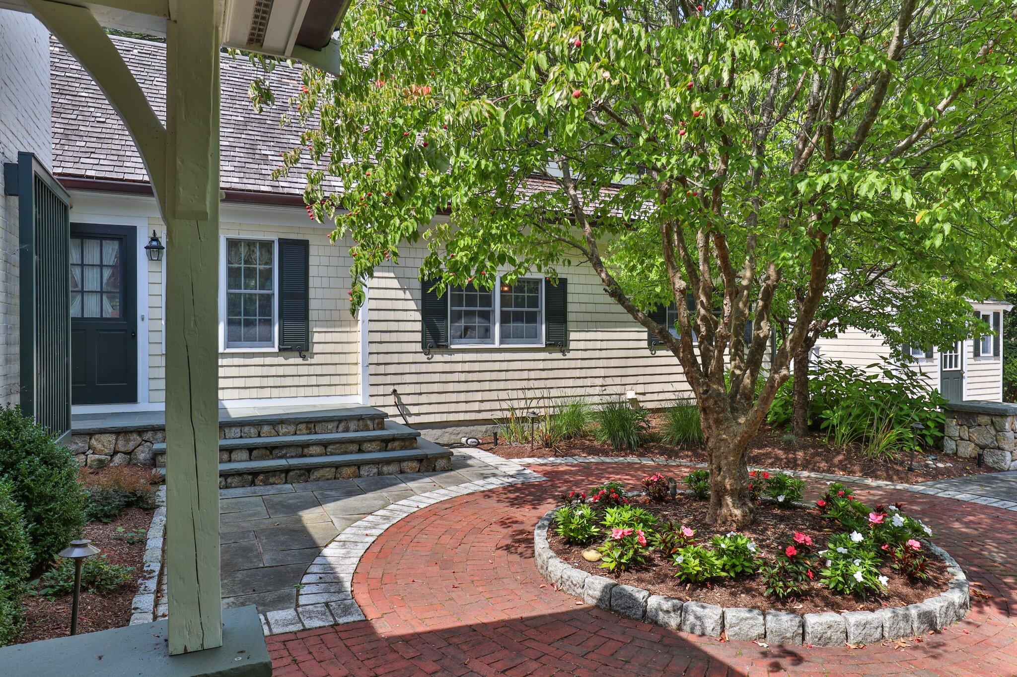 435 Huckins Neck Road Centerville, MA 02632 - Photo 8 of 42 a view of a backyard with potted plants and a large tree