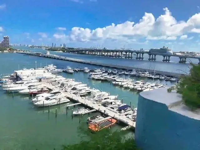 a view of a ocean with boats and trees in the background