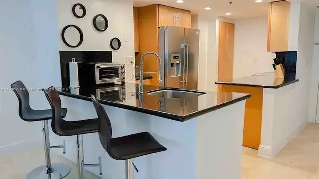 a kitchen with stainless steel appliances granite countertop a sink a stove and a refrigerator