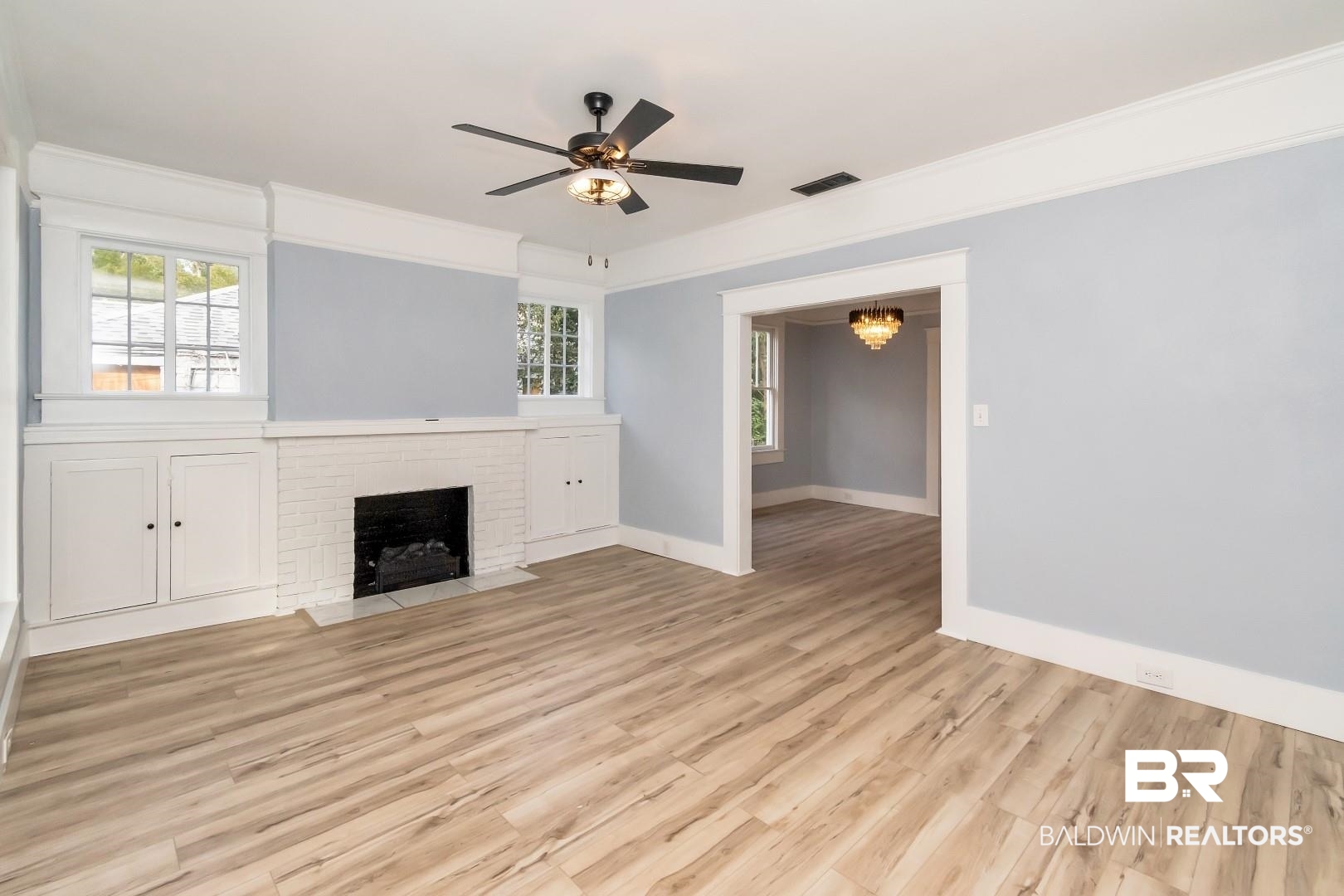 555 Michigan Avenue Mobile, AL 36604 - Photo 7 of 28 Unfurnished living room featuring ornamental molding, ceiling fan, light hardwood / wood-style floors, and a brick fireplace