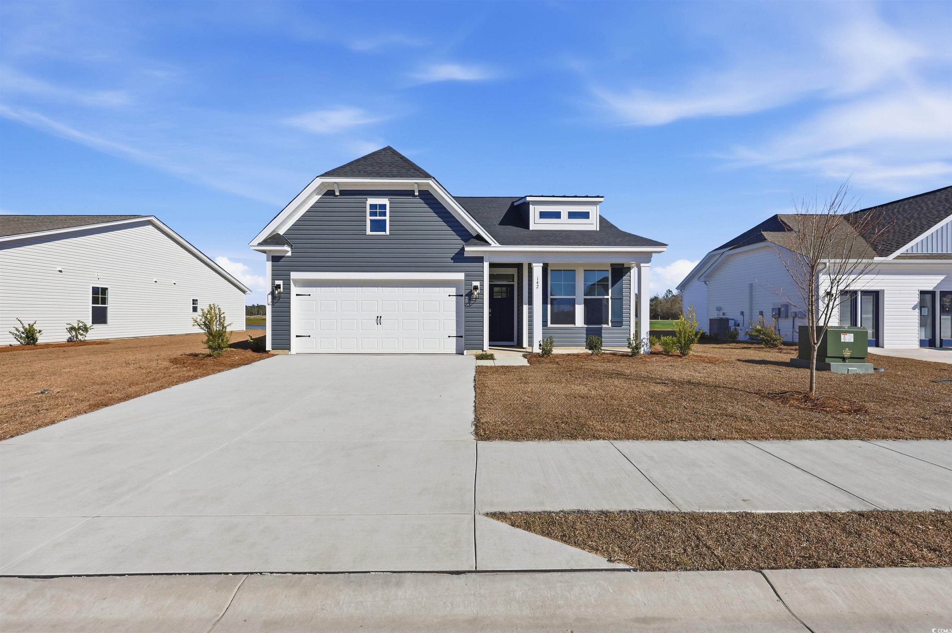 View of front of house with driveway, a shingled roof, and an attached garage
