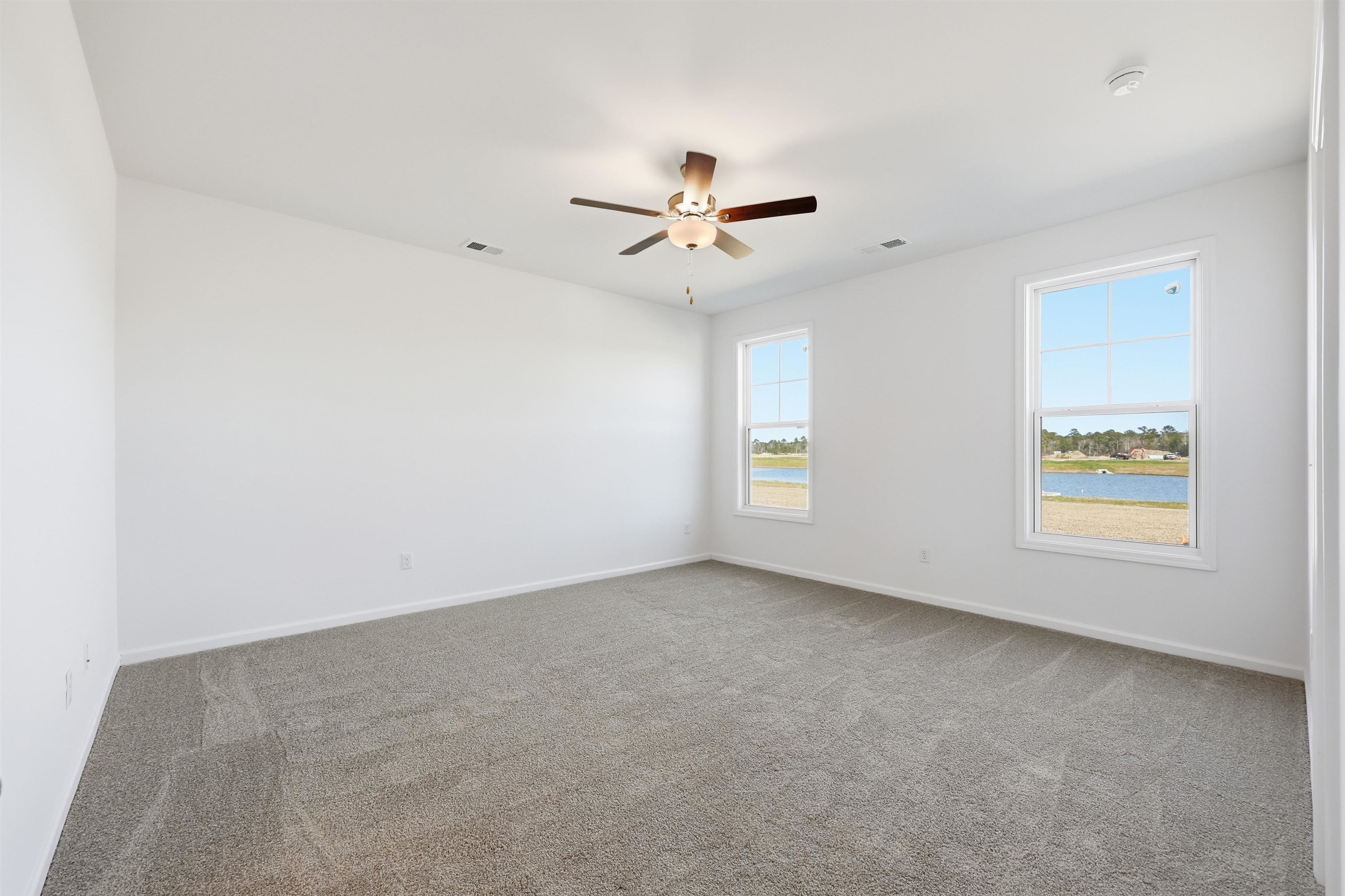 142 River Birch Drive Loris, SC 29569 - Photo 14 of 39 Spare room featuring light colored carpet, a ceiling fan, and a water view