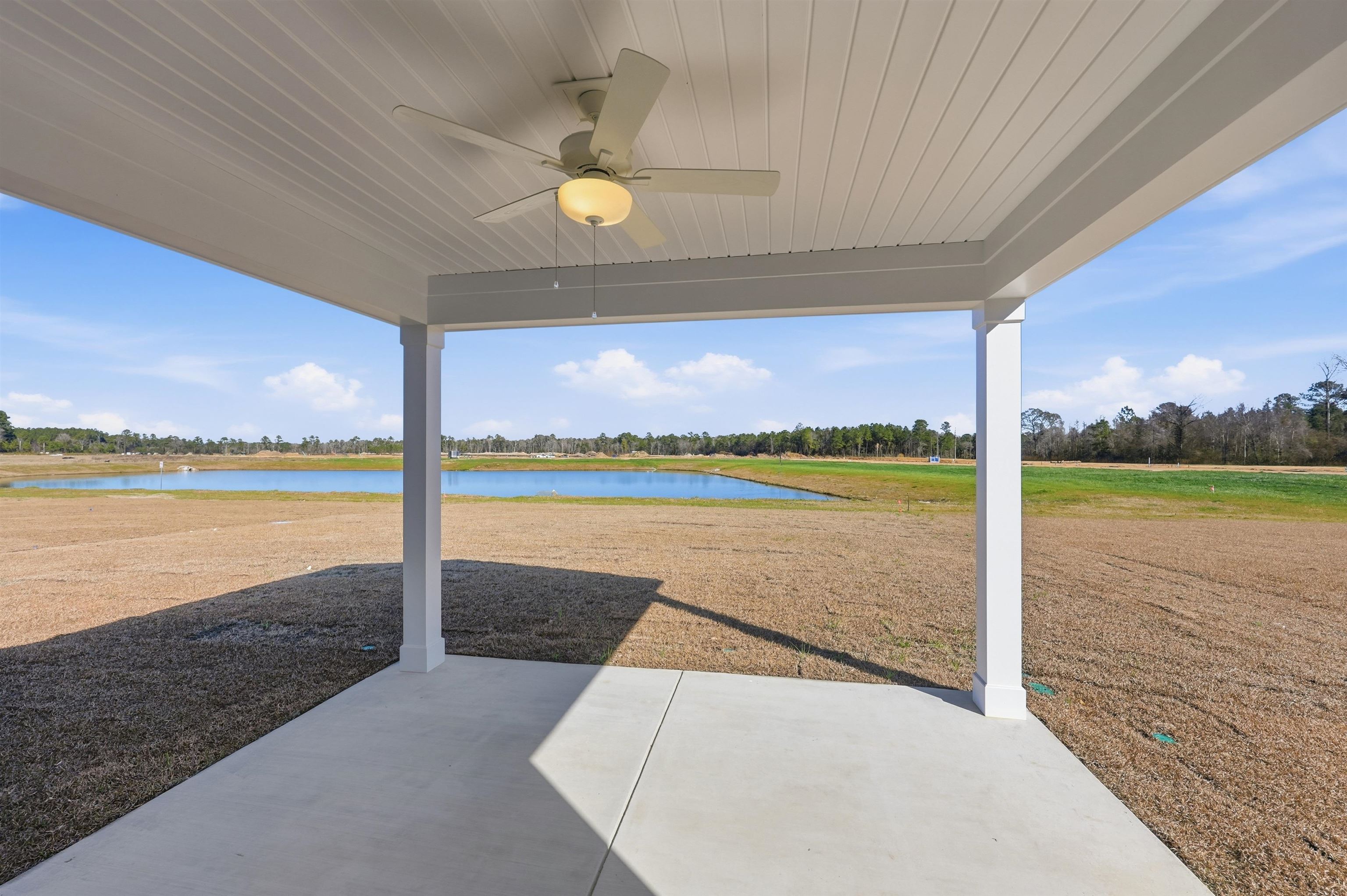 142 River Birch Drive Loris, SC 29569 - Photo 33 of 39 View of patio featuring a ceiling fan, a water view, and view of scattered trees