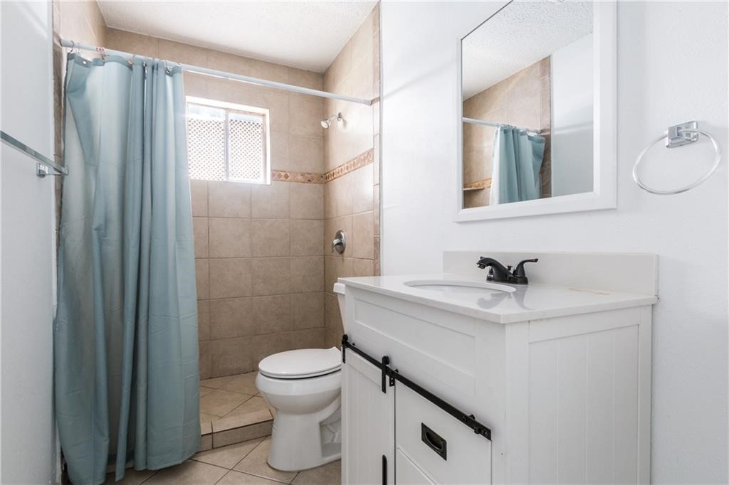 6005 Hogan Avenue Austin, TX 78741 - Photo 11 of 19 a bathroom with a sink toilet a mirror and shower