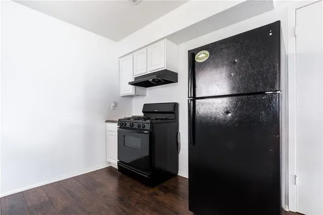 a kitchen with a refrigerator and a stove top oven