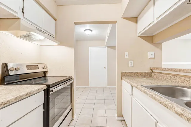 a kitchen with a sink stove and cabinets