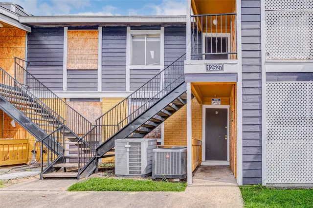 a front view of a house with a yard and potted plants