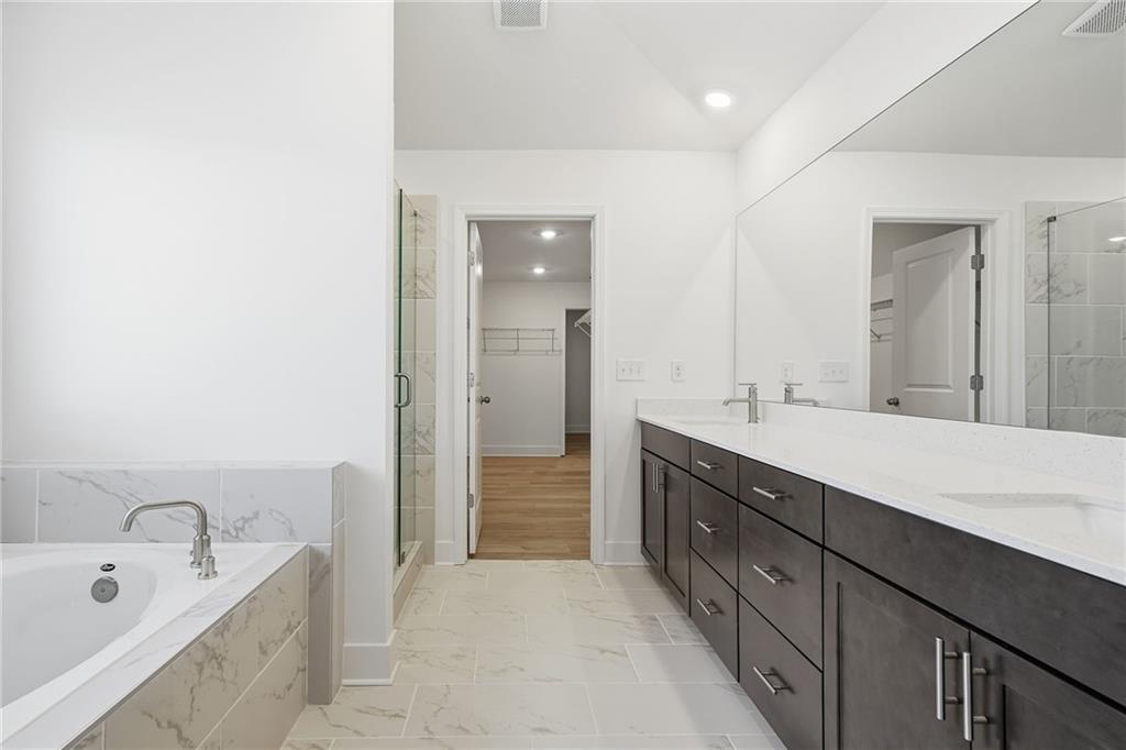 259 Deer Valley Run Canton, GA 30115 - Photo 13 of 25 a spacious bathroom with a tub sink double vanity and mirror