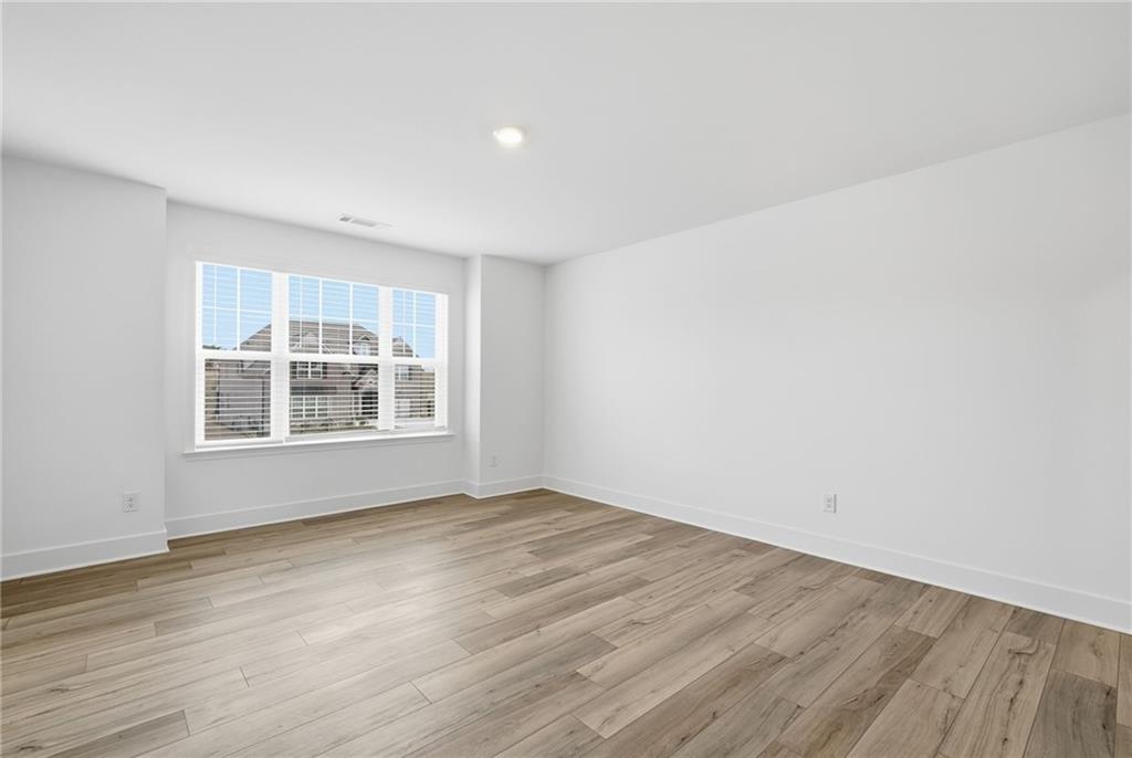 259 Deer Valley Run Canton, GA 30115 - Photo 16 of 25 a view of an empty room with wooden floor and a window