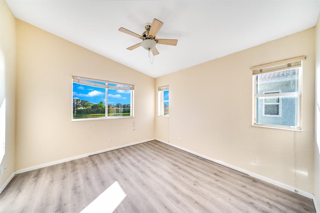3141 Laurel Ridge Circle Riviera Beach, FL 33404 - Photo 14 of 28 a view of an empty room with wooden floor and a window