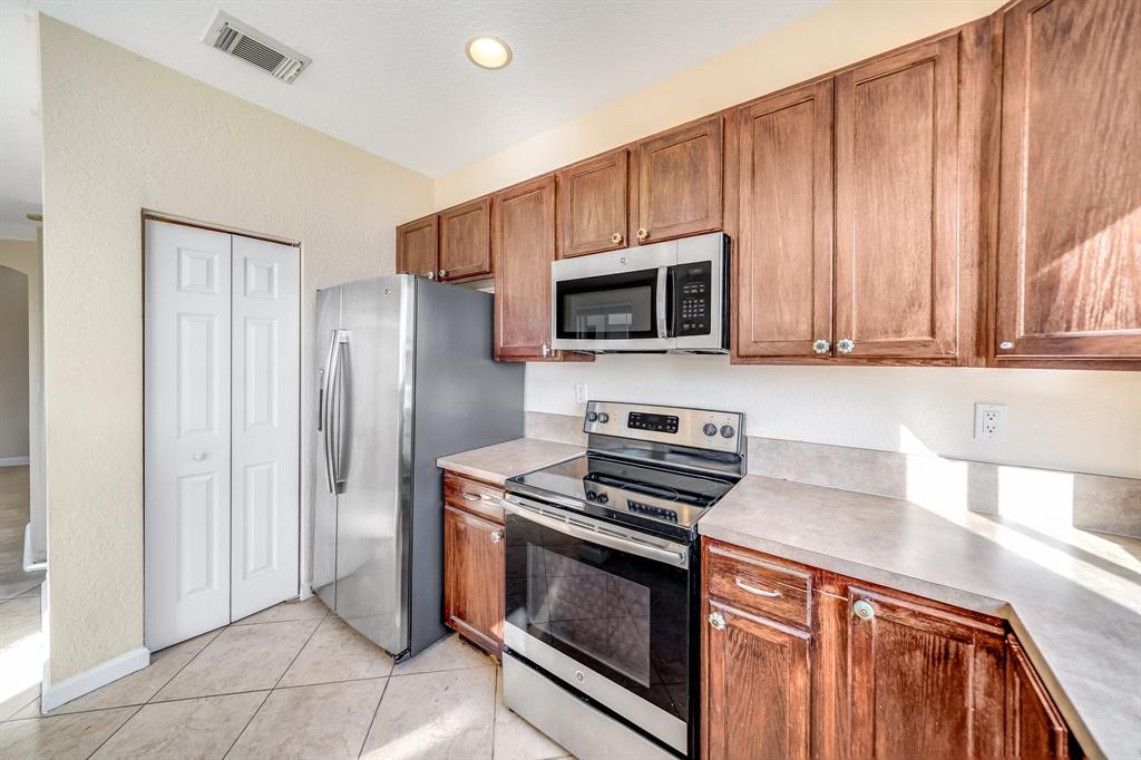 3141 Laurel Ridge Circle Riviera Beach, FL 33404 - Photo 4 of 28 a kitchen with granite countertop a stove microwave and refrigerator
