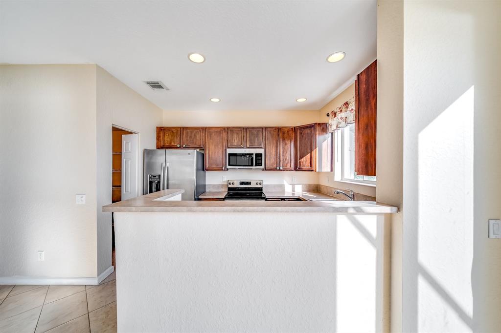3141 Laurel Ridge Circle Riviera Beach, FL 33404 - Photo 5 of 28 a kitchen with stainless steel appliances granite countertop a sink and a refrigerator