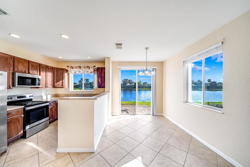 3141 Laurel Ridge Circle Riviera Beach, FL 33404 - Photo 7 of 28 a kitchen with a sink a counter top space and stainless steel appliances