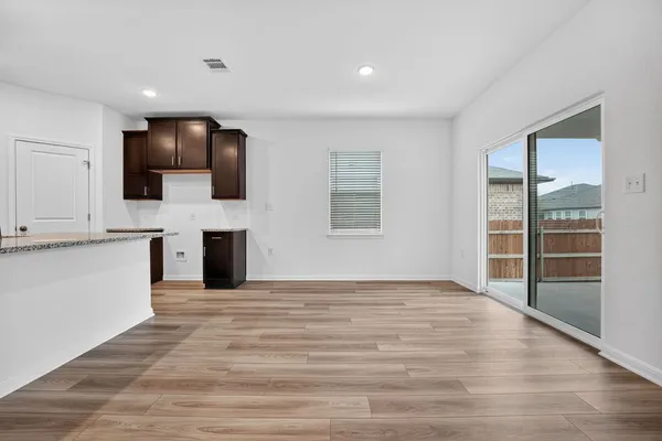 a view of empty room with wooden floor and fireplace