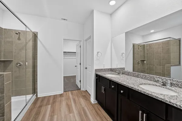 a spacious bathroom with a granite countertop sink a mirror a shower and a bathtub