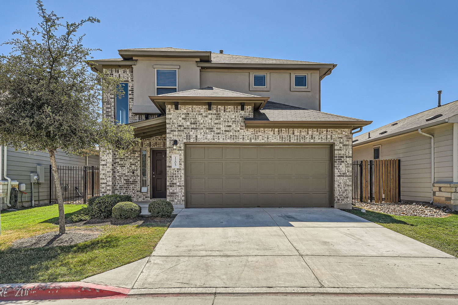 View of front of house featuring concrete driveway, stucco siding, brick siding, and a garage. Parking available for four cars.