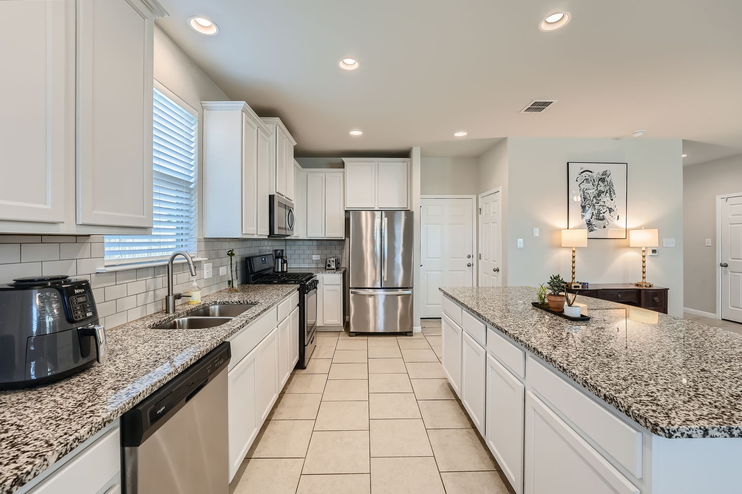1205 Falconer Way, Unit 91 Austin, TX 78748 - Photo 14 of 39 Kitchen with white cabinets, stainless steel appliances, light stone countertops, recessed lighting, and a center island