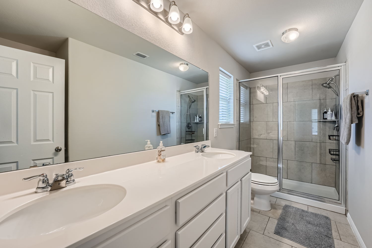 1205 Falconer Way, Unit 91 Austin, TX 78748 - Photo 22 of 39 Full bath featuring double vanity, a stall shower, and light tile patterned floors