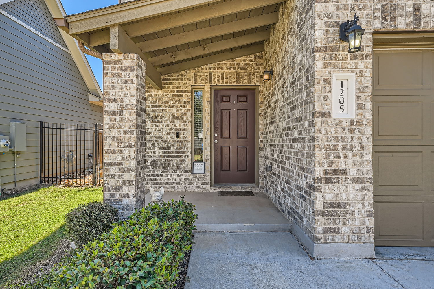1205 Falconer Way, Unit 91 Austin, TX 78748 - Photo 5 of 39 Doorway to property with covered porch, a garage, and brick siding.