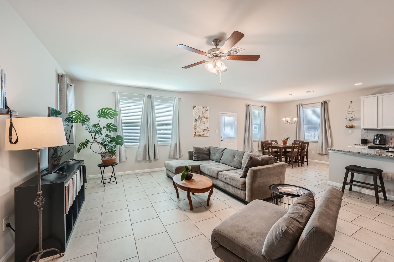 1205 Falconer Way, Unit 91 Austin, TX 78748 - Photo 8 of 39 Living area featuring a ceiling fan, light tile patterned flooring, plenty of natural light, and a chandelier