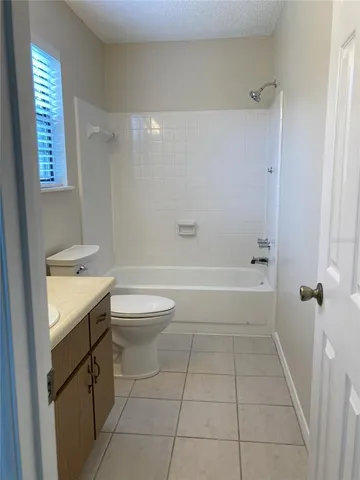 a bathroom with a granite countertop sink a toilet and shower