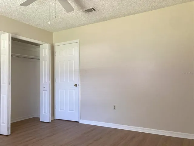 an empty room with wooden floor and closet