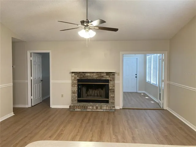 a view of empty room with wooden floor and fireplace