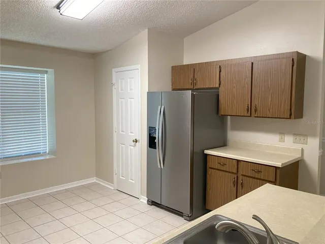 a kitchen with a refrigerator and cabinets